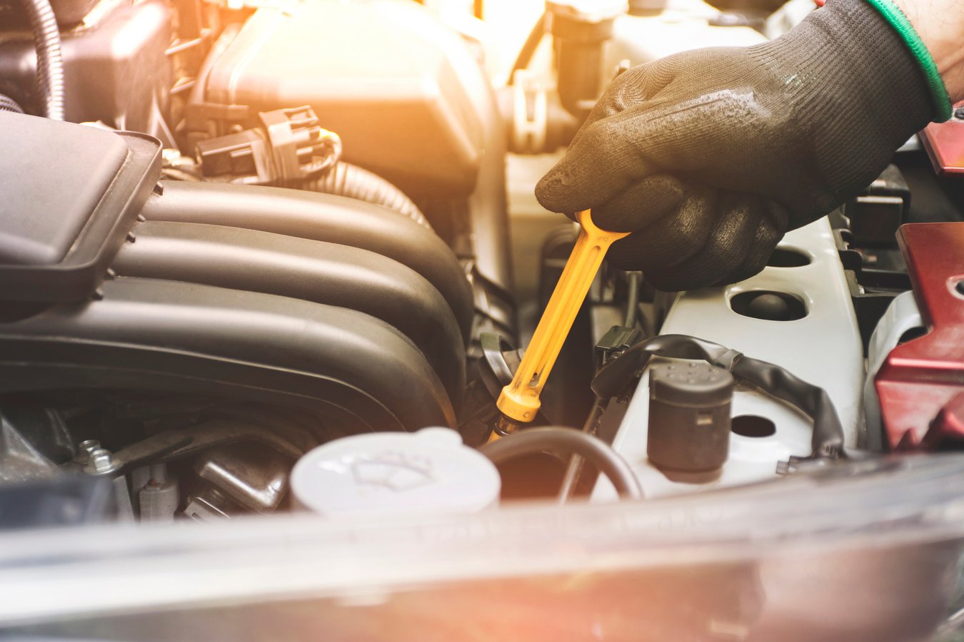 Mechanic Pulling Oil Dipstick from a Car